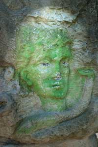 grün besprühter Kopf; Deteiaufnahme der Sandsteinmauer